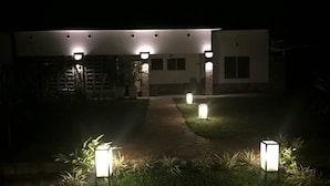 A modern building at night with multiple illuminated windows and a well-maintained lawn with decorative lighting. - Urban Lodge (Bujumbura)