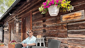 Una cabaña rústica de troncos con un letrero que dice 'LAURI GUESTS VIERAAT'.