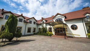 A hotel with a central entrance, multiple wings, and a courtyard. - Hotel Prezydent (Inowlodz)