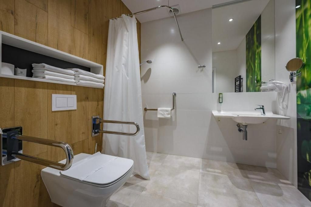 Un baño moderno con ducha, inodoro y lavamanos.