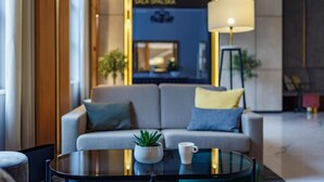 A modern lobby with a sofa, a coffee table, and a lamp. - Hotel Prezydent (Inowlodz)