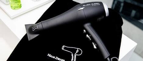 A black hair dryer with a white logo on a white surface.