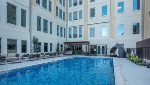 An indoor swimming pool with lounge chairs and a covered seating area. - Brand New Stunning Unit Downtown (Dallas)