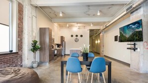 A modern interior with a dining area, kitchen, and a large painting on the wall. - Beautiful 3bd Unit in Perfect Downtown Location (Dallas)