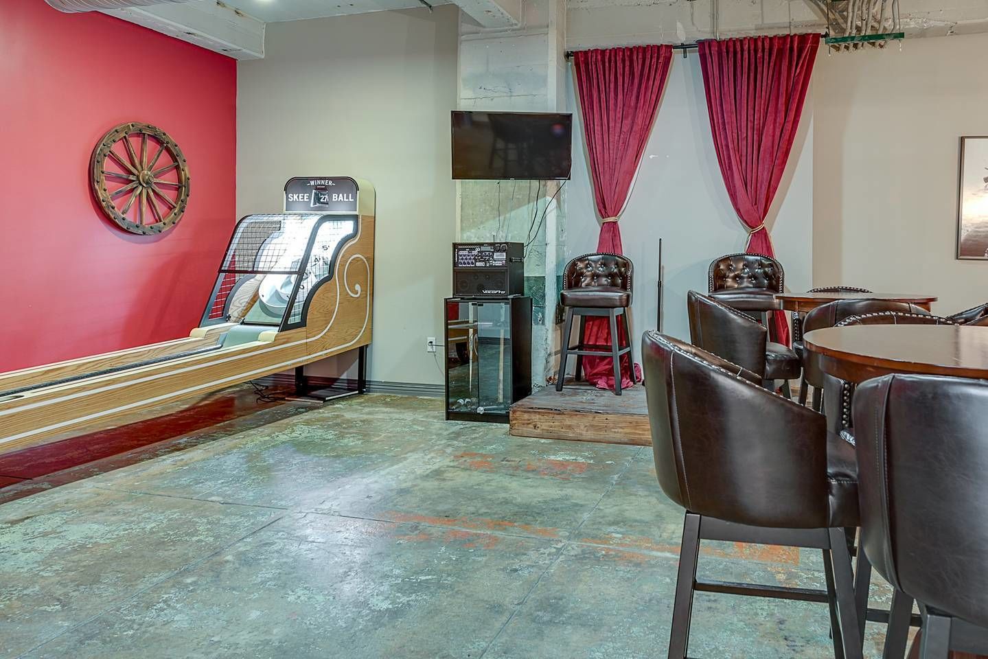 Une salle avec un juke-box, un jeu de fléchettes et une table de billard.