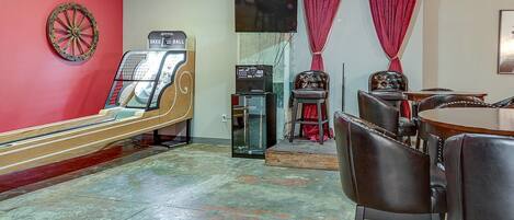 Une salle avec un juke-box, un jeu de fléchettes et une table de billard.