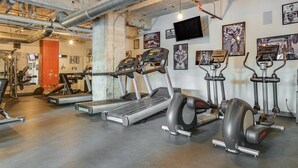 A gym with treadmills, elliptical machines, and weightlifting equipment. - Downtown Dallas Gorgeous 3 BD, Pool & Gym (Dallas)