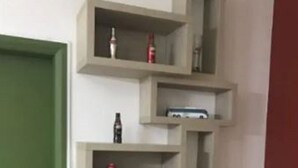 Uma cozinha com prateleiras embutidas, uma porta verde e uma bancada com um rádio e um eletrodoméstico.