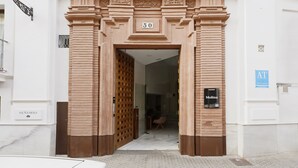 A building entrance with a large number '50' above the door, a sign reading 'Molina', and a 'SEÑORIO' sign on the left. - Numa Seville Molina (Seville)