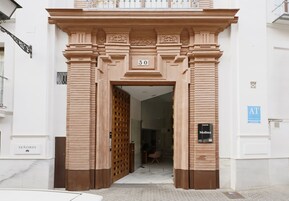 A building entrance with a large number '50' above the door, a sign reading 'Molina', and a 'SEÑORIO' sign on the left.