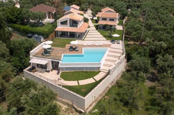 A modern villa with a swimming pool, outdoor seating, and a well-maintained garden. - Evylio Stone Houses (Zakynthos)