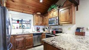 A kitchen with wooden cabinets, stainless steel appliances, and a granite countertop. - Woodlands #33 3 Bedroom Condo by RedAwning (Mammoth Lakes)