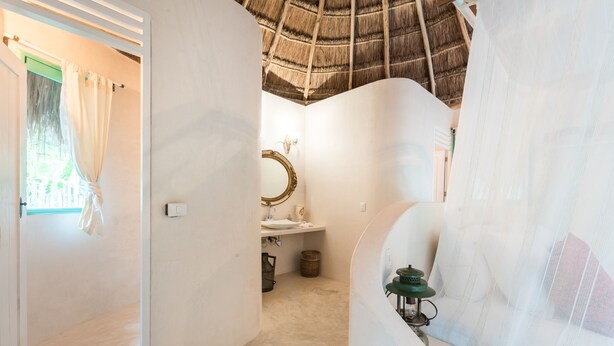 A bathroom with a bathtub, a mirror, and a shower curtain. - Cormoran Boutique Hotel & Cenote Tulum (Tulum)