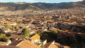 A panoramic view of a city with a dense urban layout, surrounded by mountains. - Apartments Stunning View San Blas (Cusco)