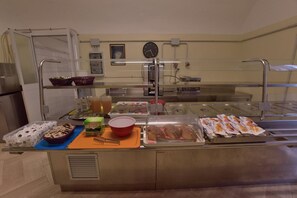 Una mesa de buffet con diversos alimentos y utensilios.