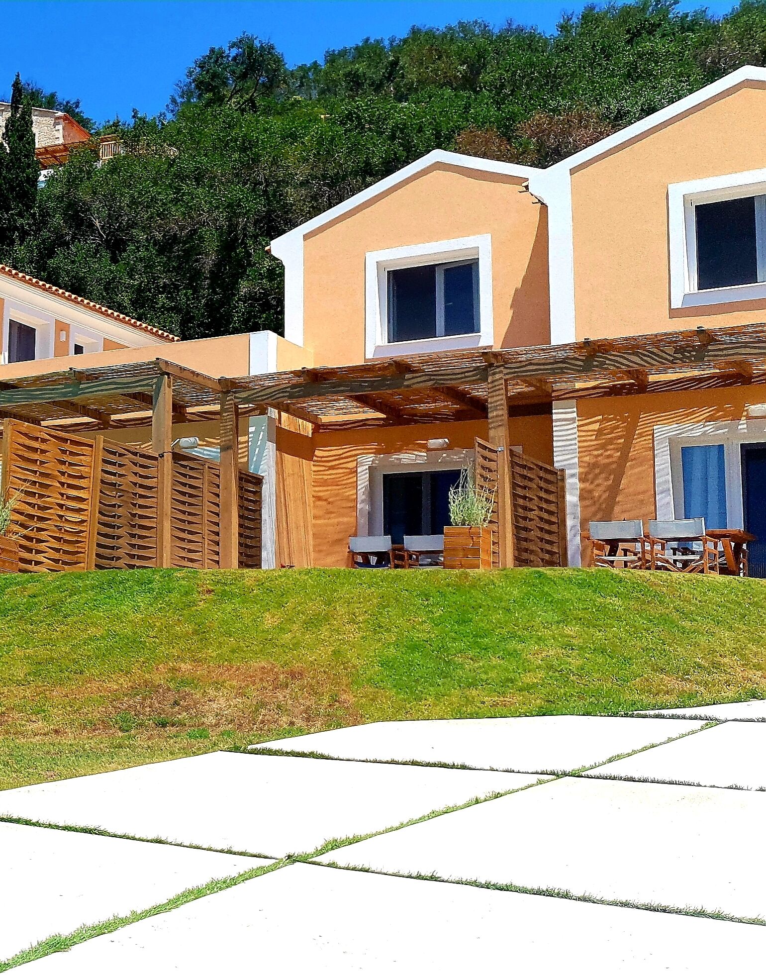 A two-story building with a covered patio area and outdoor seating.