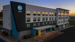 A modern hotel building with a prominent 'tru by Hilton' sign, multiple windows, and a well-lit entrance area. - Tru by Hilton Lubbock Southwest (Lubbock)