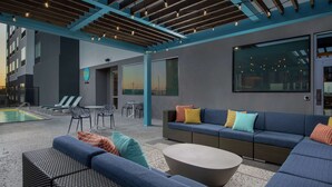 A modern outdoor lounge area with seating, a pool, and a view of the cityscape. - Tru by Hilton Lubbock Southwest (Lubbock)