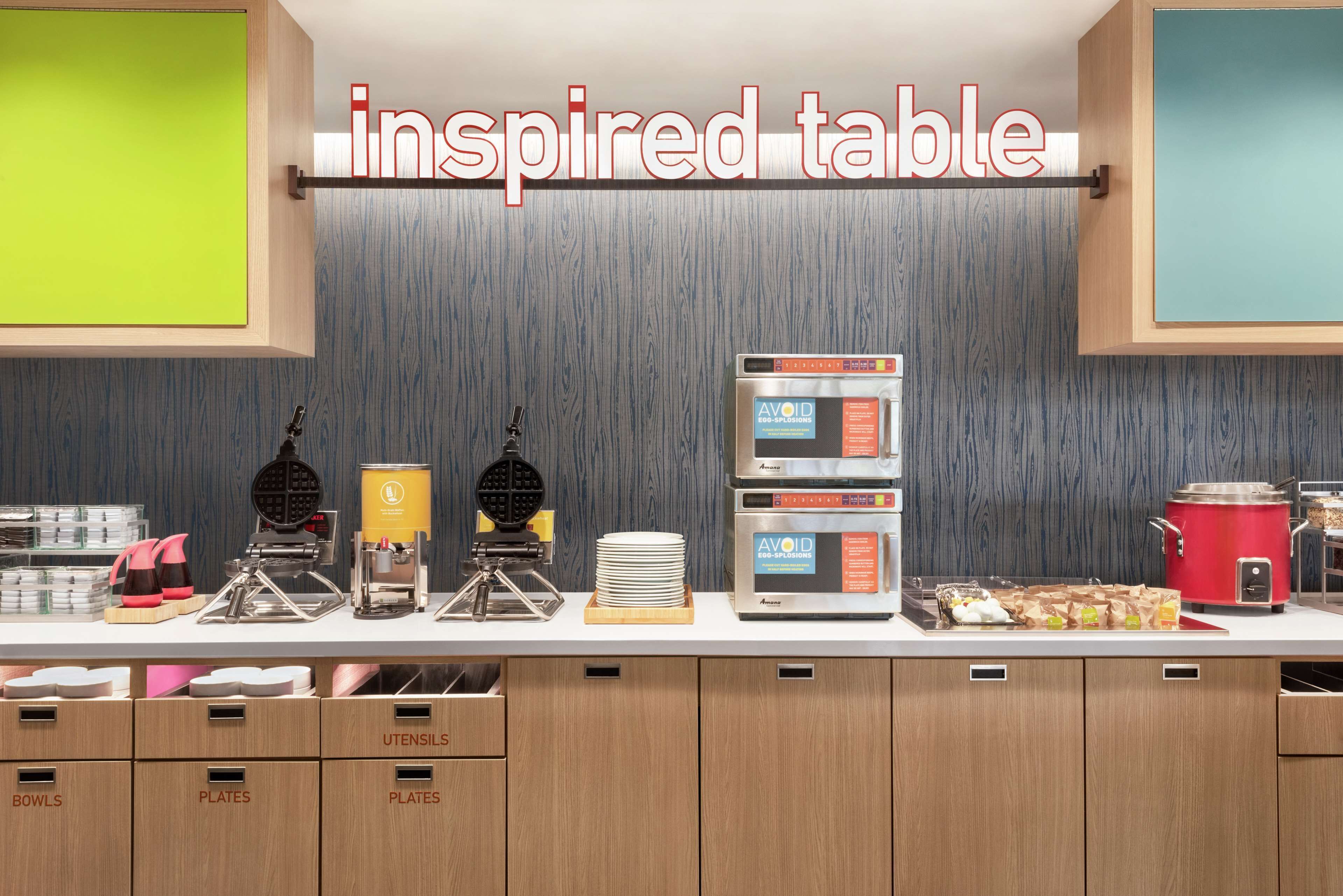 A kitchen area with a countertop displaying various cooking appliances, utensils, and food items.