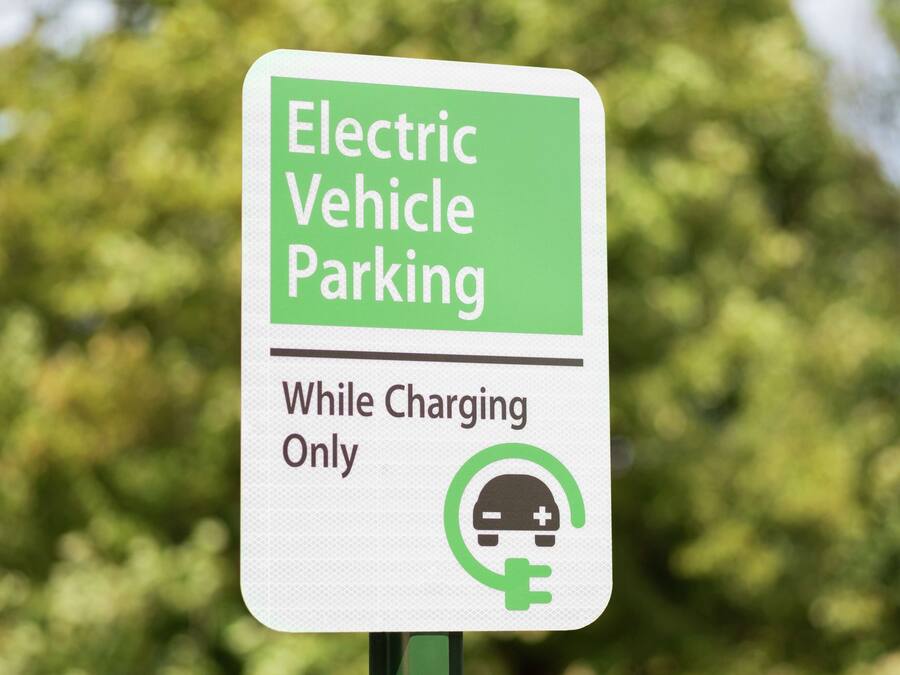 Señal que indica estacionamiento para vehículos eléctricos mientras se cargan.