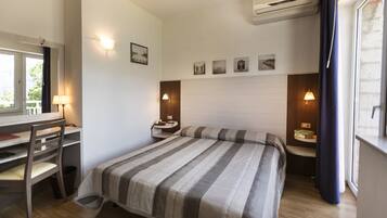 Ein Hotelzimmer mit Bett, Schreibtisch, Stuhl und Nachttischen.