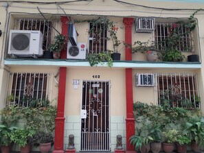 Two-story building with ornate gate, lion statues, and decorative iron grilles.