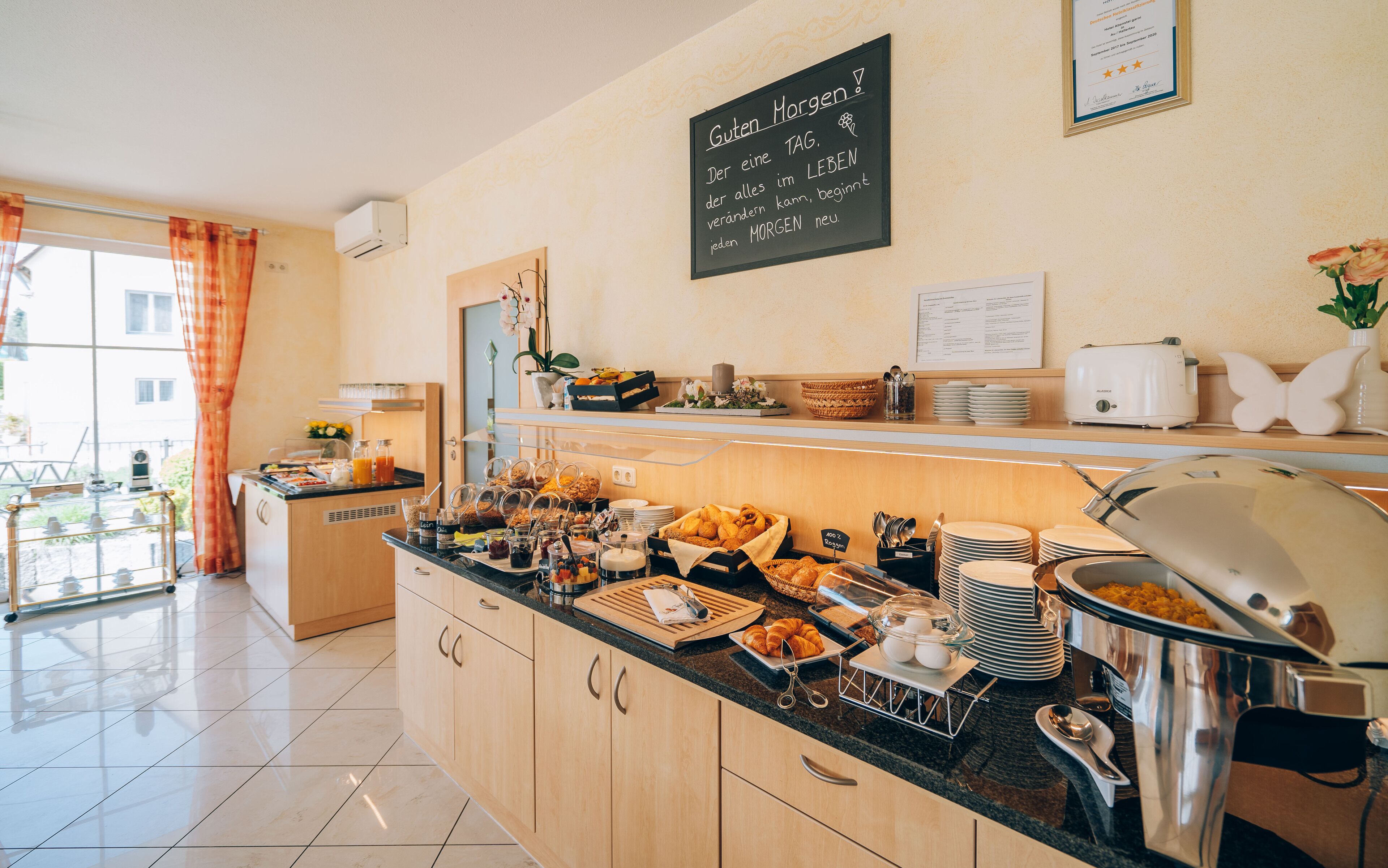 A breakfast buffet with various food items and a chalkboard sign.