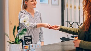A reception desk with a sign reading "RECEPTION" and a counter with credit card machines. - Hotel Abenstal (Au in der Hallertau)