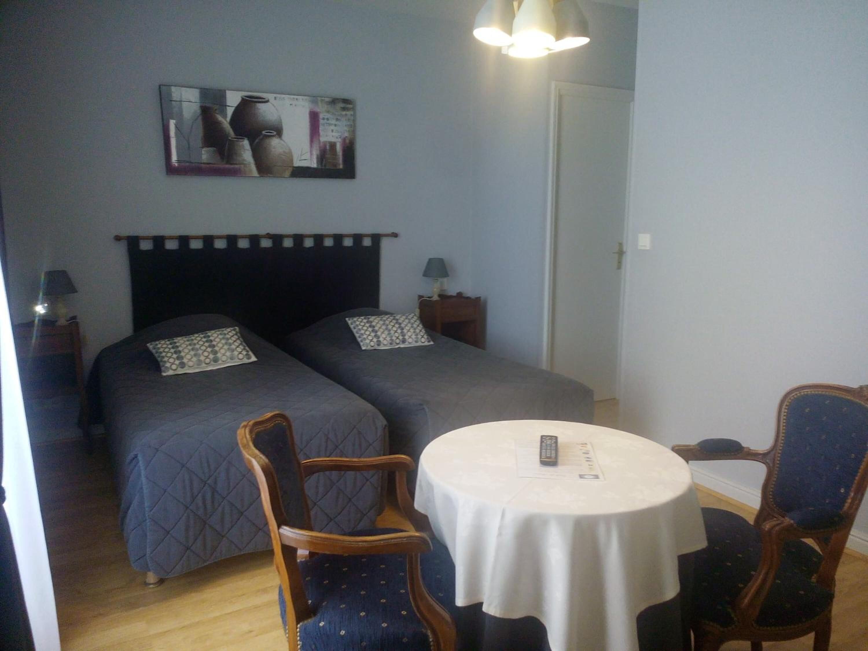 Een kamer met twee bedden, een ronde tafel en twee stoelen.