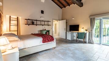 Ein Schlafzimmer mit Bett, Nachttisch, Lampe und Schreibtisch mit Stuhl.