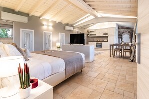 Quarto com cama, mesa de cabeceira, abajur e planta em vaso.