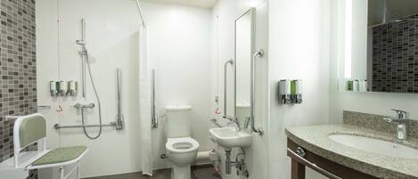 Een moderne badkamer met douche, toilet en wastafel.