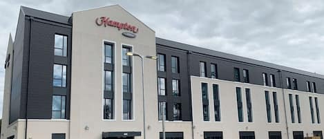 Un moderno edificio de Hampton con techo plano, grandes ventanales y una entrada destacada.