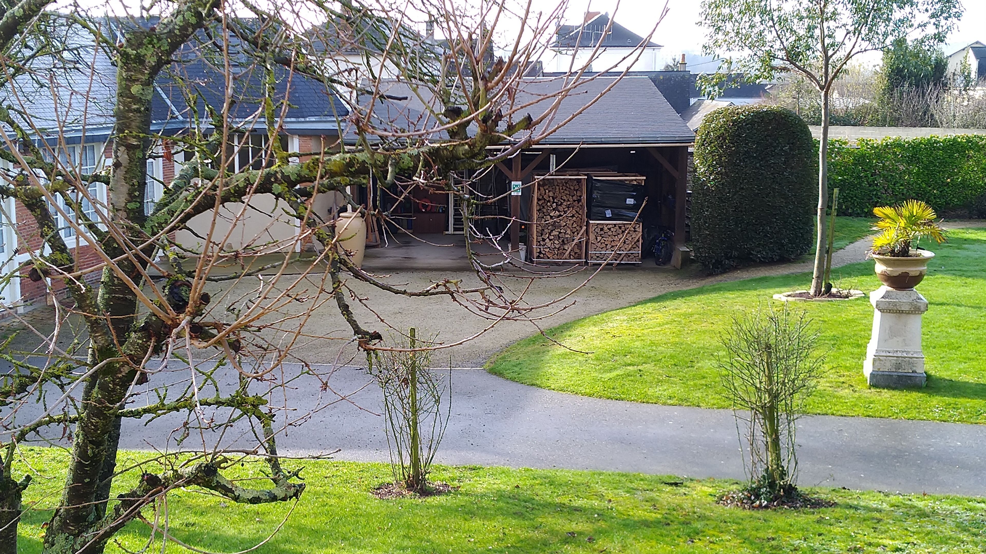 A residential property with a paved driveway, a garage, and a well-maintained lawn.