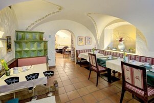 A restaurant with arched ceilings, green cabinets, and tables set for dining.