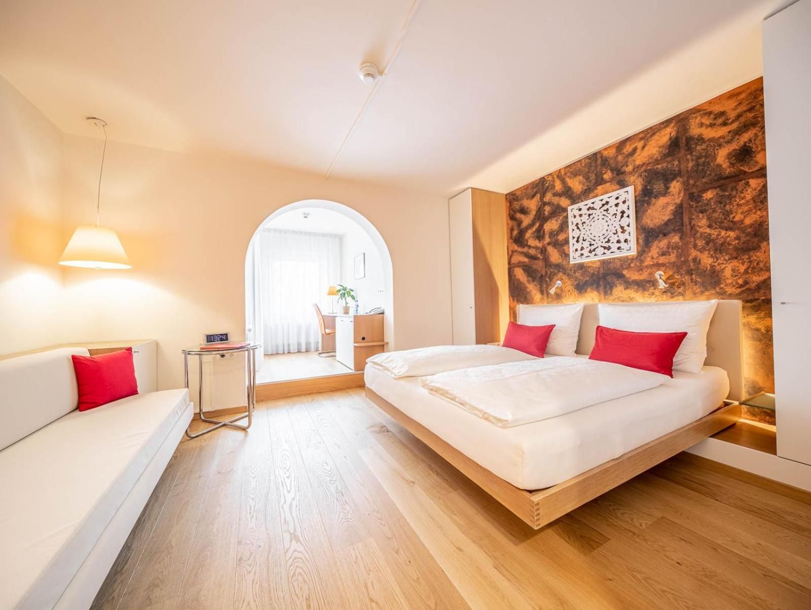Ein modernes Hotelzimmer mit Bett, Schreibtisch und einer Sitzecke.