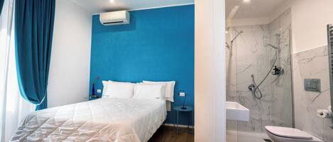 A modern bedroom with a large bed, a bedside table, and a nightstand.