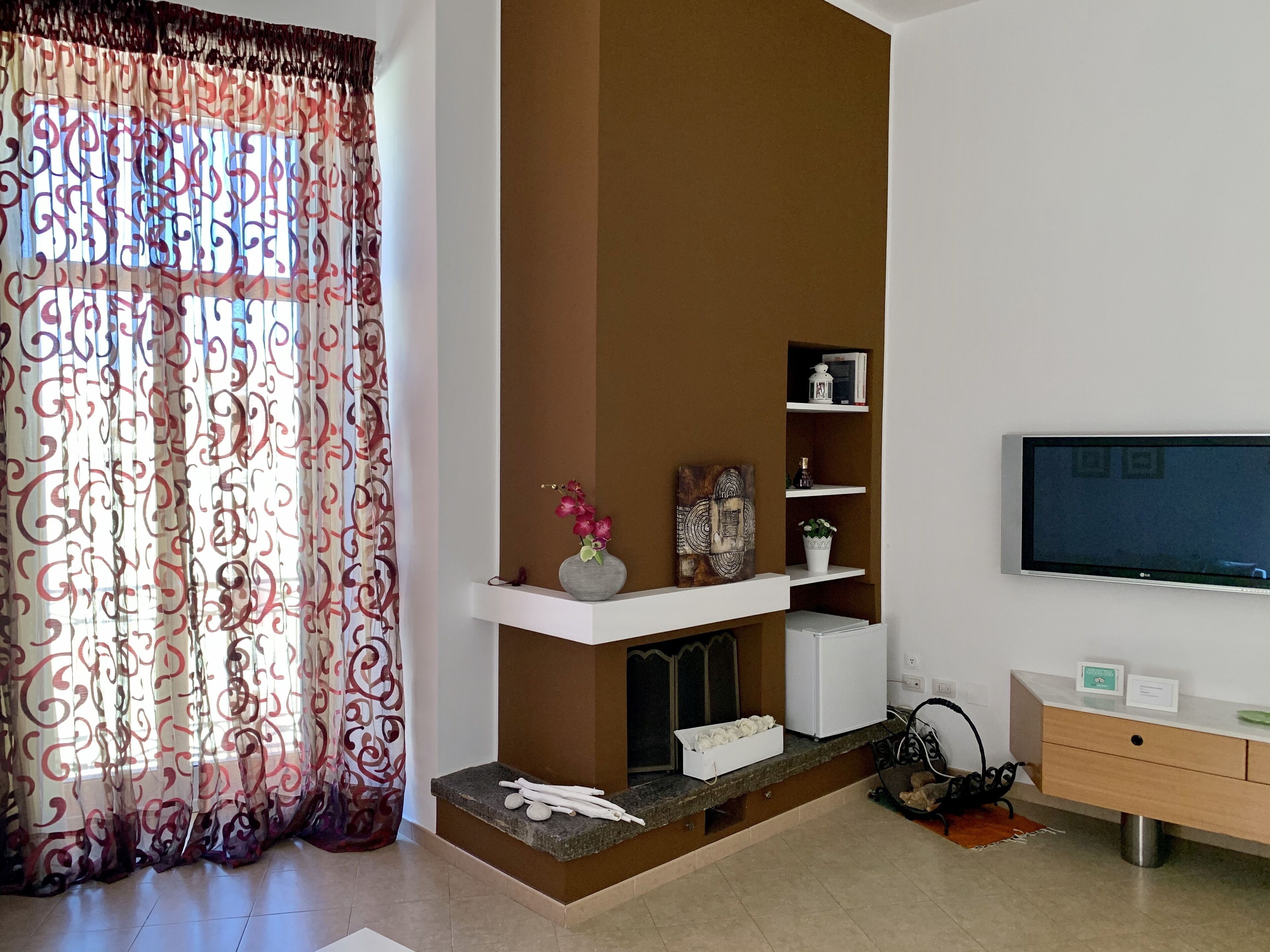 Una sala moderna con chimenea, televisor de pantalla plana y decoración minimalista.