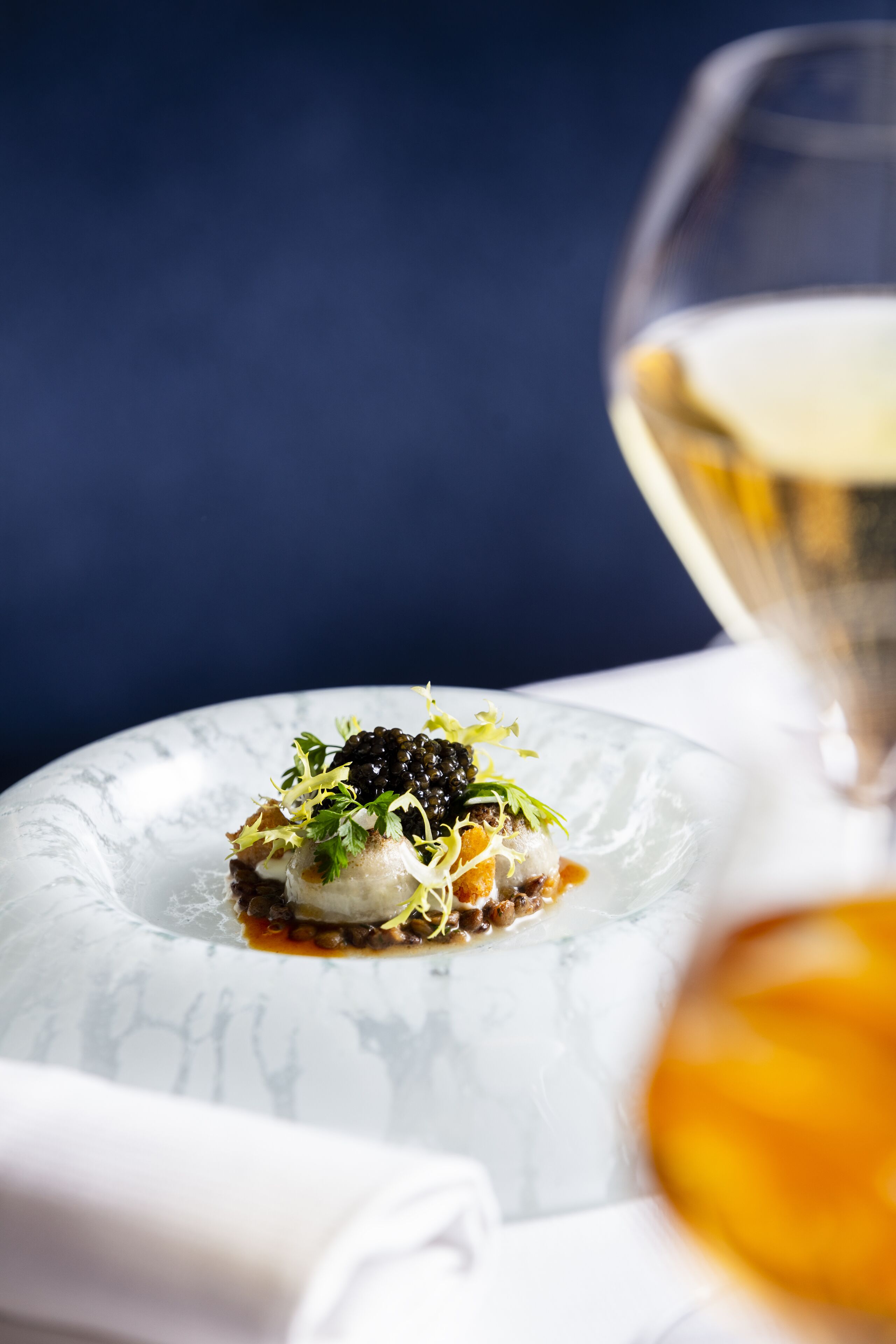 Un dessert présenté sur une assiette en verre transparent, avec un fond sombre.