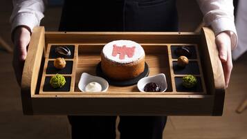 A wooden tray with a cake and various small desserts.