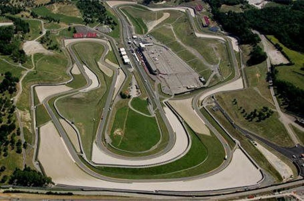 Vista aerea di una pista di corsa con diverse curve e un rettilineo.