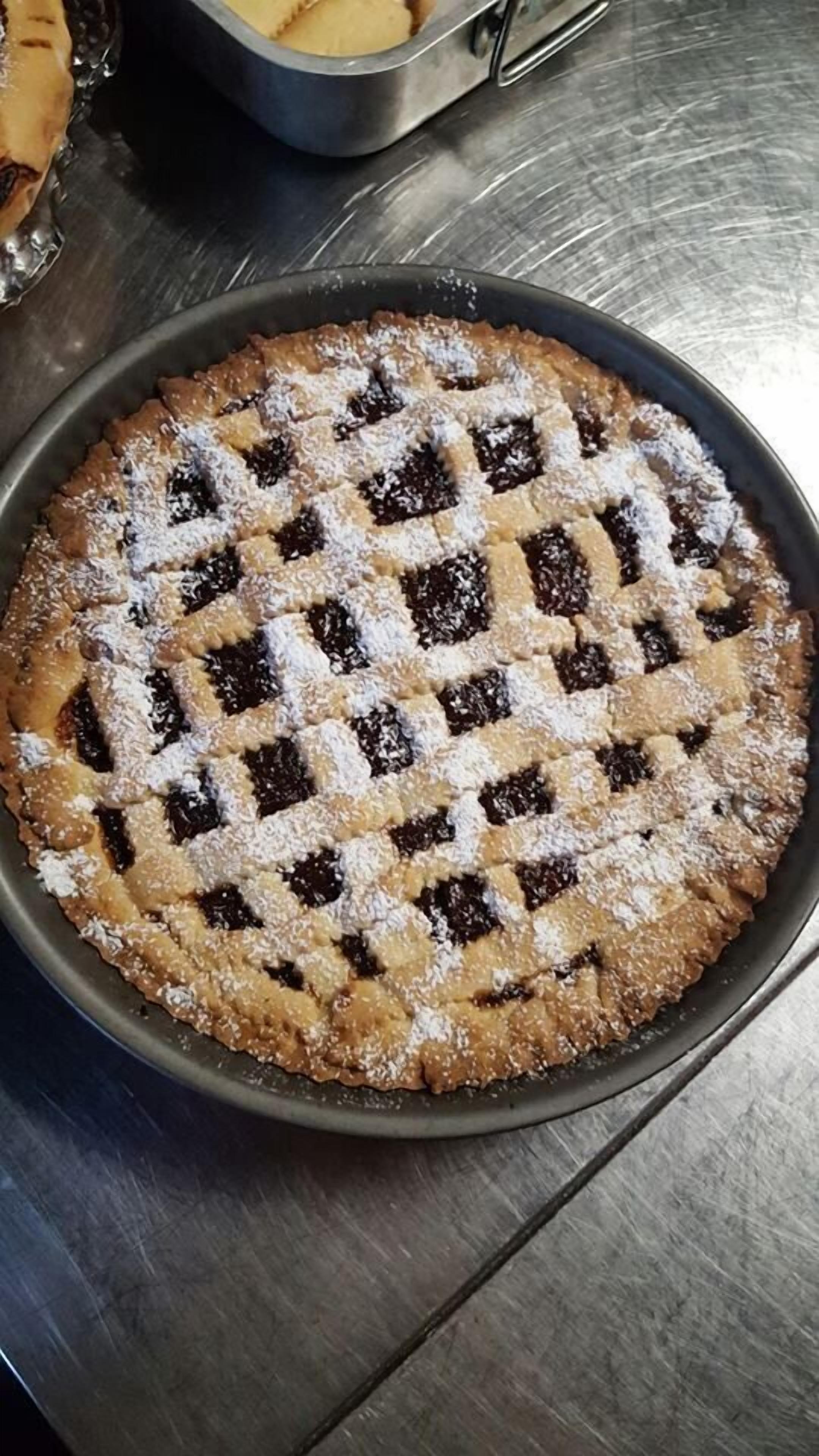 A round pie with a lattice crust on a metal plate.