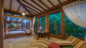 Una habitación acogedora con una cama, un escritorio y vistas a exuberante follaje.