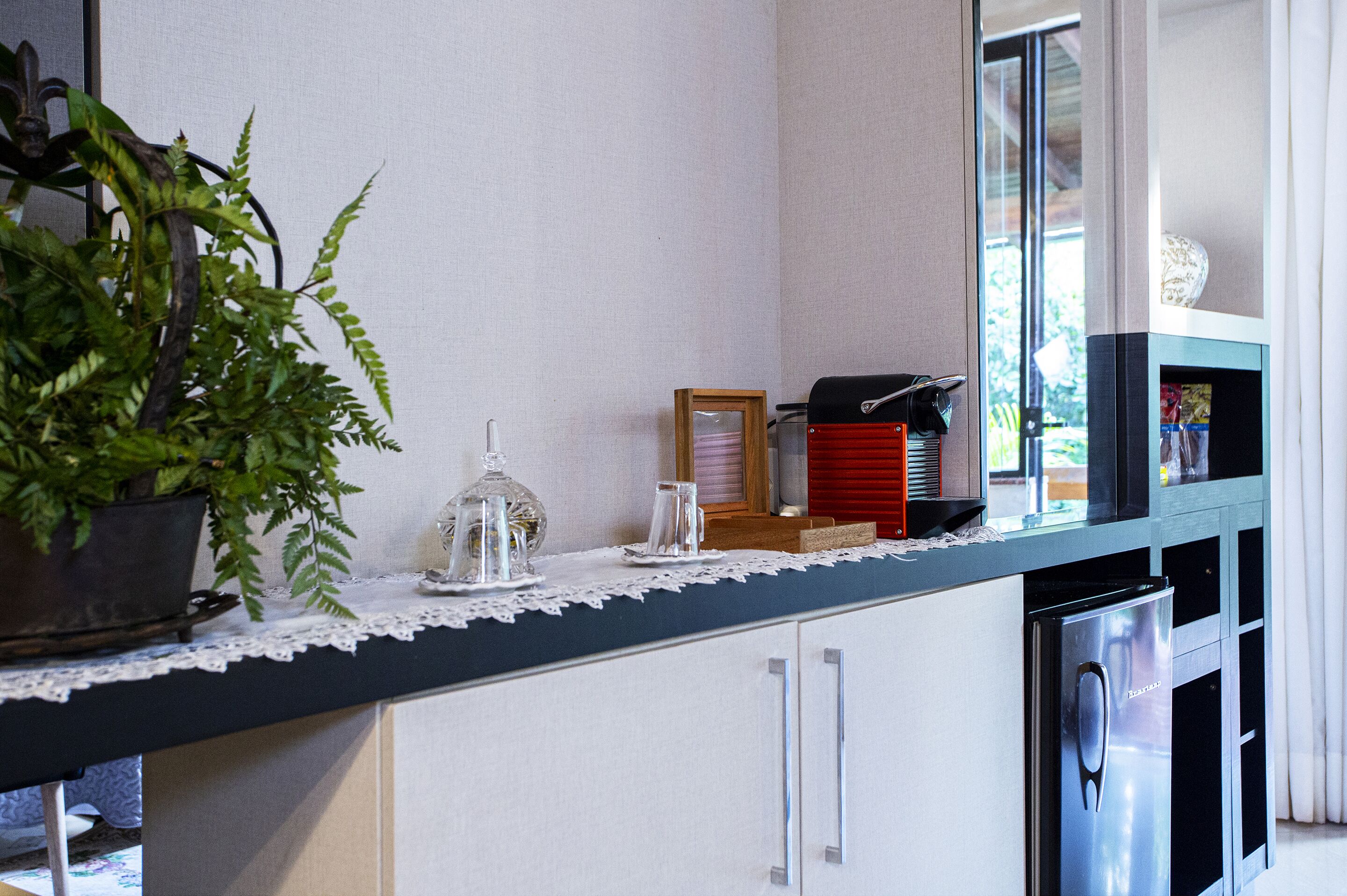 A kitchen counter with a potted plant, a glass jar, and a framed picture.