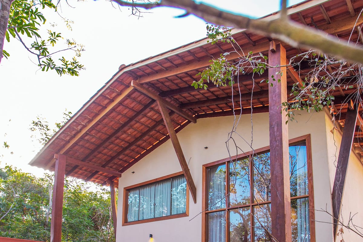 A two-story house with a swimming pool, large windows, and a covered patio area.