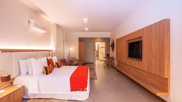 Una habitación de hotel moderna con una cama grande, un televisor montado en la pared y un diseño de paneles de madera.