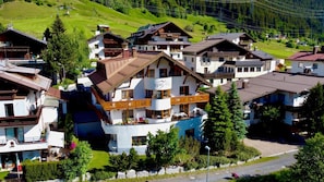 A multi-story hotel with balconies, a pool, and a ski lift in the background. - Aparthotel Alpin Life (Sankt Anton am Arlberg)