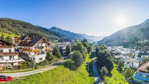 A mountain village with traditional wooden houses, a clear road, and a valley. - Aparthotel Alpin Life (Sankt Anton am Arlberg)