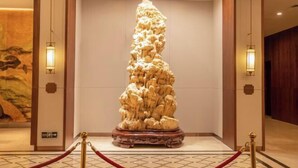 A sculpture in a lobby with a red rope barrier. - Good Fortune Hot Spring Hotel (Donghai)