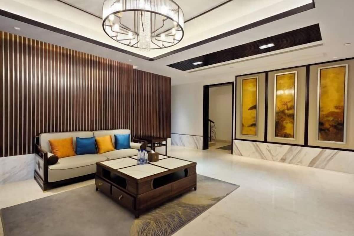 A modern living room with a sofa, coffee table, and artwork on the walls.